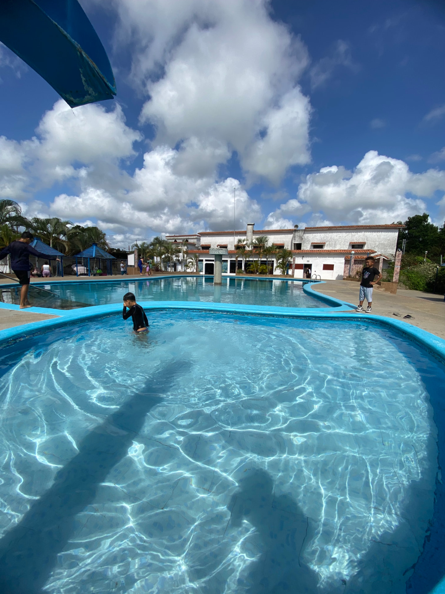Piscina de Posada Century en Río Chico con niños disfrutando en un día soleado